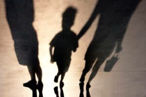 Shadows of boy with mother, with father turns his back
