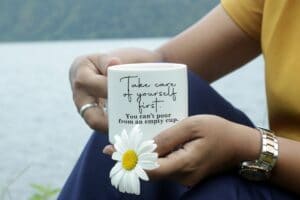 Woman holding a mug that says, 'take care of yourself first, you can't pour from an empty cup'